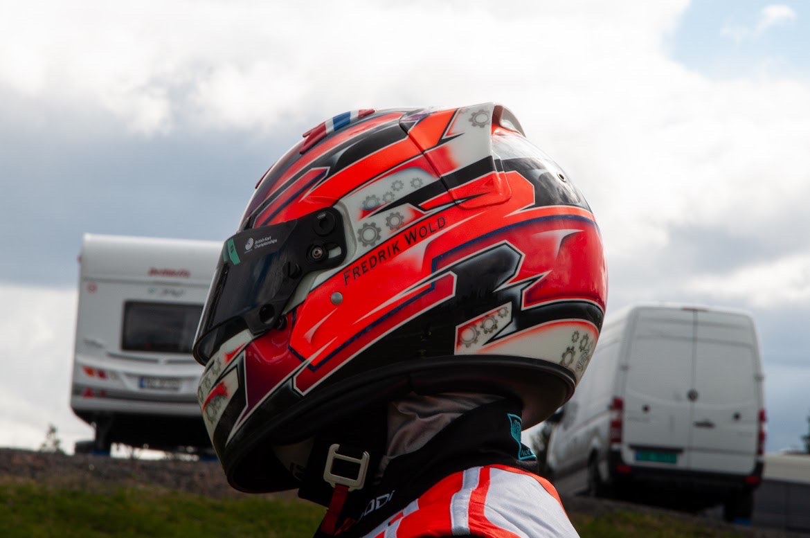 Fredrik Wold race helmet — red, black and white livery with gear motifs