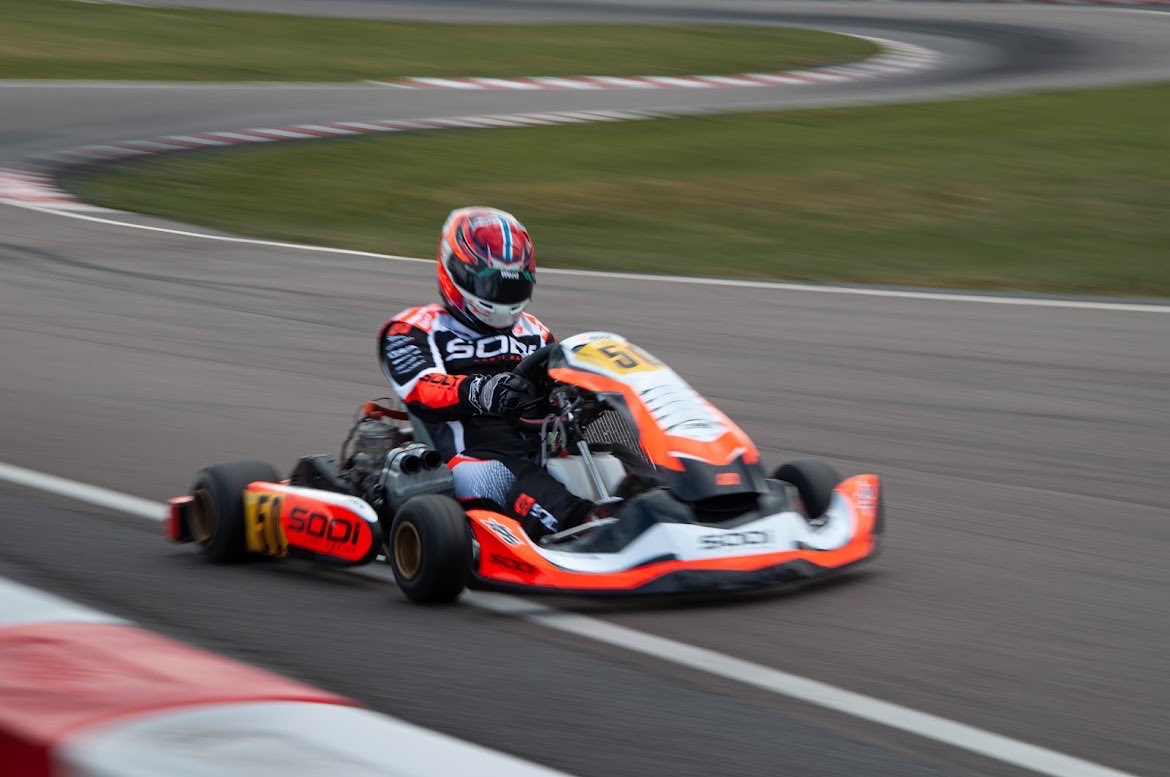 #5 driver cornering at speed wearing a custom-designed race helmet